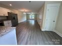 Open-concept living area with modern flooring and natural light, leading to the kitchen at 307 Messner St, Salisbury, NC 28144