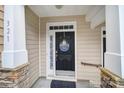 A welcoming front door with decorative wreath and a sidelight window, complemented by stone and column accents at 321 Rose Garden Ct, Rock Hill, SC 29732