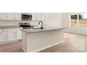 Close-up of kitchen island featuring granite countertop, stainless steel appliances, and shaker cabinets at 3457 Bear Den Dr, Gastonia, NC 28052