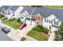 An aerial view shows a neighborhood of townhouses, showcasing their landscaping, driveways, and overall layout at 4208 Carl Parmer Dr, Harrisburg, NC 28075