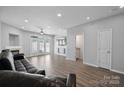 Spacious living room with fireplace, ceiling fan, french doors to outside, and wood look flooring at 4211 Center Place Dr, Harrisburg, NC 28075