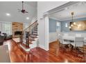 Open entryway featuring hardwood floors, staircase, stone fireplace, and adjacent dining room at 4552 Sawgrass Ct, Denver, NC 28037