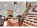 Spacious living room with stone fireplace, hardwood floors, high ceilings, and large windows at 4552 Sawgrass Ct, Denver, NC 28037
