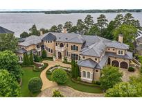 Stunning lakefront home features professionally landscaped grounds with elegant stonework and a meticulously maintained lawn at 18019 Harbor Light Blvd, Cornelius, NC 28031
