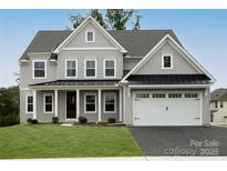 Charming new construction home featuring a gray exterior, lush lawn, and a two-car garage at 11318 James Coy Rd # Devonshire, Davidson, NC 28036
