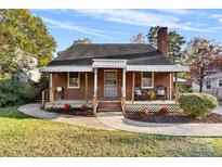 Brick house with front porch, rocking chairs, and landscaped lawn at 3726 The Plaza None, Charlotte, NC 28205