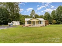 Charming cottage-style home with a well-maintained lawn, shed, and inviting front porch at 225 Shore Acres Rd, Salisbury, NC 28146