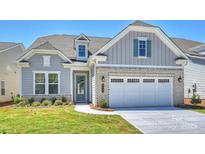 Charming two-story home featuring a mix of brick and siding with an attached two-car garage at 6043 Waldorf Ave, Monroe, NC 28110