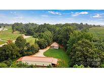 Secluded home nestled among lush trees, boasting a private driveway and a spacious outbuilding at 6051 Pointe West Ln, Vale, NC 28168