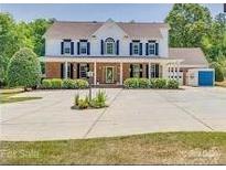 Stately two-story home with a full front porch, lush landscaping, and ample parking space at 1491 Hwy 160 E Rd, Fort Mill, SC 29715