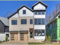 Stunning two-story home featuring a stone facade and modern wood garage doors at 914 Laurel Creek Ln, Charlotte, NC 28211