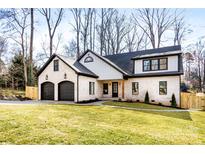 Two-story white brick home with black accents, two-car garage, and landscaped lawn at 3038 Northampton Dr, Charlotte, NC 28210