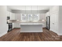 Bright kitchen featuring white cabinets, stainless steel appliances, and a large center island at 417 Prine Pl # Brx0013, Charlotte, NC 28213