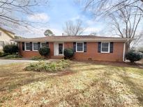 Charming red brick ranch-style home with a well-maintained lawn and classic black shutters at 6200 Swift Arrow Ln, Charlotte, NC 28214