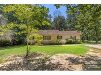 Charming home featuring a well-manicured front yard and mature trees creating a peaceful setting at 1302 Hickory Nut Ln, Lincolnton, NC 28092