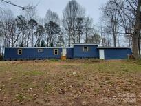 Single-story blue home featuring wood shutters and a gravel yard at 230 Ellen St, Salisbury, NC 28146