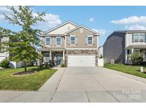 Two-story home featuring stone accents, a two-car garage, and a well-manicured lawn in a suburban neighborhood at 107 Gray Willow St, Mooresville, NC 28117