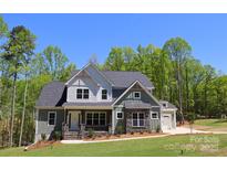 Two-story home featuring stone accents, a covered front porch, and an attached two-car garage at 106 Windbluff Ct # 163, Statesville, NC 28677