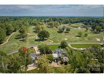 Aerial view of a beautiful property on a golf course with lush greenery and mature trees at 218 Fairway Dr, Shelby, NC 28150