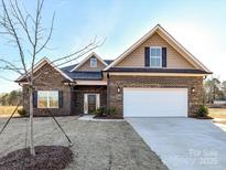 Charming brick home featuring a two-car garage, well-manicured lawn, and inviting front entrance at 1108 Piper Meadows Dr # 52, Waxhaw, NC 28173