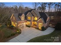 Stunning two-story brick home boasts a large driveway and manicured landscaping with accent lighting at 2012 Tomshire Dr, Gastonia, NC 28056
