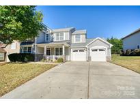 Two-story house with gray siding, stone accents, and a two-car garage at 1148 Mckee Farm Ln, Belmont, NC 28012