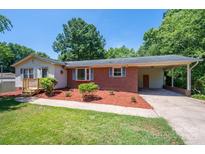 Brick ranch house with carport, landscaping, and a spacious yard at 1571 Branchville Rd, Shelby, NC 28150