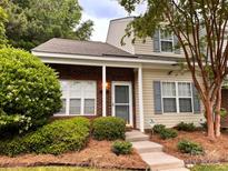 Charming two-story townhome featuring brick accents and a well-maintained front yard at 10875 Holly Ridge Blvd, Charlotte, NC 28216