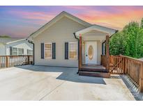 Charming single-story home showcasing a welcoming front porch and a large concrete driveway at 159 Badin Lake Cir, New London, NC 28127