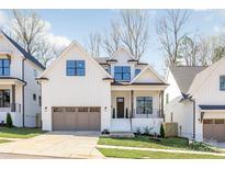 Charming two-story home featuring a modern design, white siding, and a two-car garage with attractive landscaping at 3945 Plainview Rd, Charlotte, NC 28208