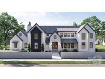 Striking two-story home features a stylish mix of white brick and dark accents at 4658 Sugar Plum Ln, Davidson, NC 28036