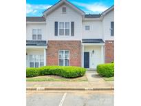 Two story brick and white townhome with landscaping and parking at 6436 Mallard View Ln, Charlotte, NC 28269