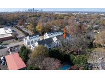 An aerial view shows the white townhomes in the fall with the Charlotte skyline in the distance at 1409 Collier Walk Aly # Csw0104, Charlotte, NC 28205