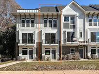 Beautiful townhome featuring white siding, large windows, and a charming balcony, offering modern elegance and curb appeal at 1211 E 34Th St # Csw0313, Charlotte, NC 28205