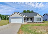 Charming single-story home with a two-car garage, blue siding and a well-manicured lawn on a sunny day at 6122 Lowder Rd, Salisbury, NC 28147