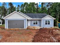 Charming single-story home featuring a gray garage door, light blue vinyl siding, and a well-manicured lawn at 6155 Long Branch Rd, Salisbury, NC 28147