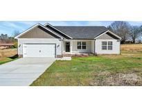 Charming single-story home featuring a two-car garage, tidy landscaping, and a welcoming front porch at 6155 Long Branch Rd, Salisbury, NC 28147