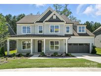 Charming two-story home featuring a covered front porch, manicured lawn, and attached two-car garage at 2016 Cedar Falls Dr # 7, Waxhaw, NC 28173