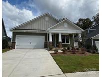 Two-story house with a green and beige exterior, two-car garage, and landscaping at 503 Tates Trl # 8, Cramerton, NC 28032