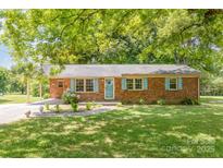 Brick ranch house with light blue shutters, landscaping, and a covered porch at 621 Oak Grove Rd, Kings Mountain, NC 28086