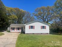 White Ranch style home with red shutters and a spacious yard at 915 Timberlane Dr, Mount Holly, NC 28120