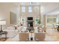 Bright living room features a fireplace, tall windows, and neutral furniture at 4023 Randolph Rd, Charlotte, NC 28211
