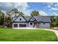 Charming two-story home featuring a well-manicured lawn and three-car garage at 116 Emmaline Ct, Troutman, NC 28166