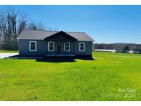 Charming single-story home featuring a covered porch, gray siding, and a well-maintained green lawn at 8255 W Nc 10 Hwy, Vale, NC 28168