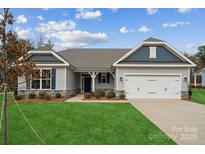 Charming single-story home featuring a well-manicured lawn, gray siding, and a spacious two-car garage at 105 Brooke Forest Ct, Mooresville, NC 28115