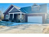 Brick house with a stone facade, 2-car garage, and covered porch at 1302 Devonmere Pl, Salisbury, NC 28144