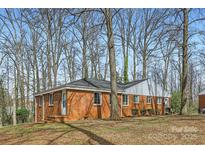 Charming brick home with a well-maintained lawn and mature trees providing shade and curb appeal at 3210 Marlborough Rd, Charlotte, NC 28208