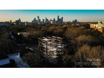 Aerial view of building frame under construction, city skyline in background at 409 Queens Rd # 204, Charlotte, NC 28207