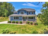 Two-story house with gray siding, stone accents, and a landscaped lawn at 4243 Island Fox Ln, Denver, NC 28037