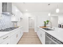 Modern white kitchen with stainless steel appliances, gas range and stylish backsplash at 2627 Ashbourne Dr, Gastonia, NC 28056